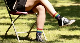 Een persoon waarvan enkel de benen zichtbaar zijn en die regenboogkousen aanheeft